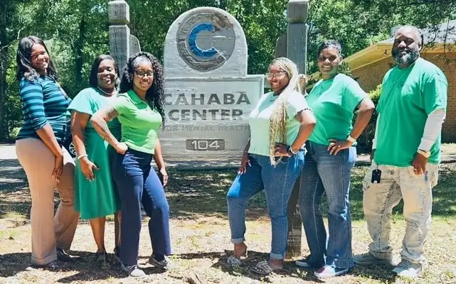 Cahaba Center for Mental Health staff in front of the Cahaba Center sign